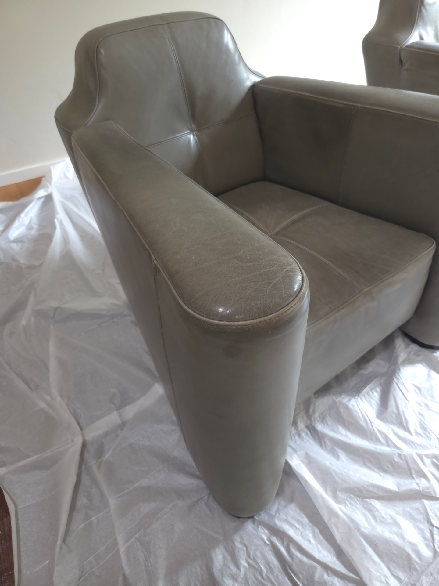 Voor behandeling: armleuning van leren fauteuil met gebruikssporen