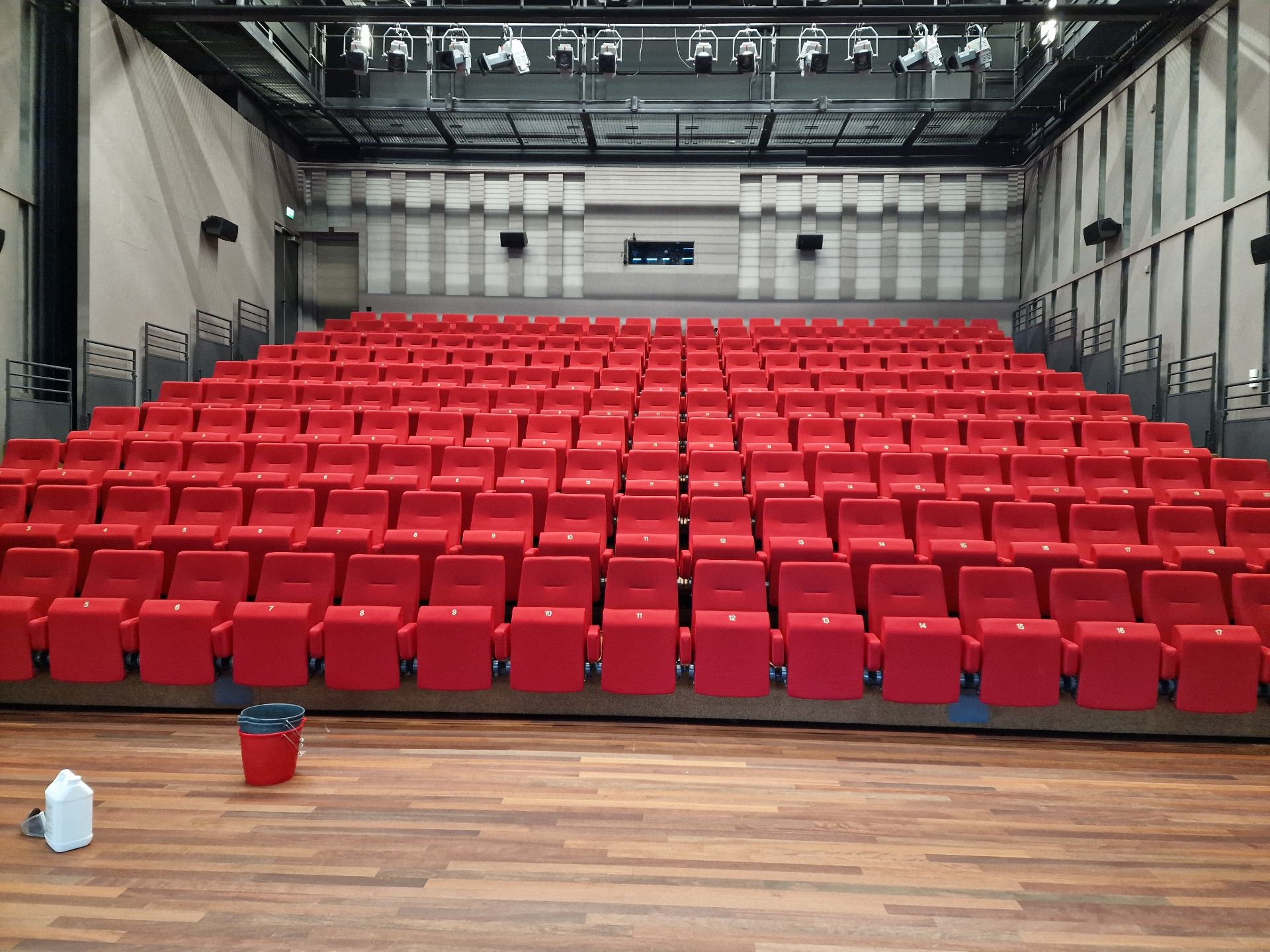 Rijen rode theaterstoelen in een schouwburgzaal — professioneel gereinigd op locatie