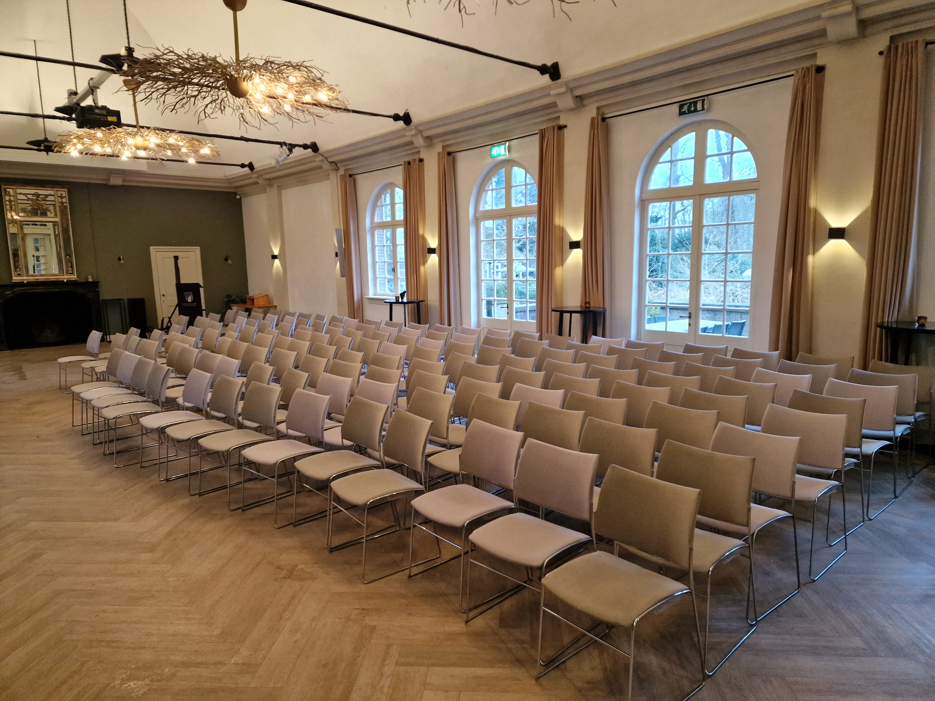 Rijen beige gestoffeerde vergaderstoelen in een klassieke zaal — professioneel gereinigd op locatie
