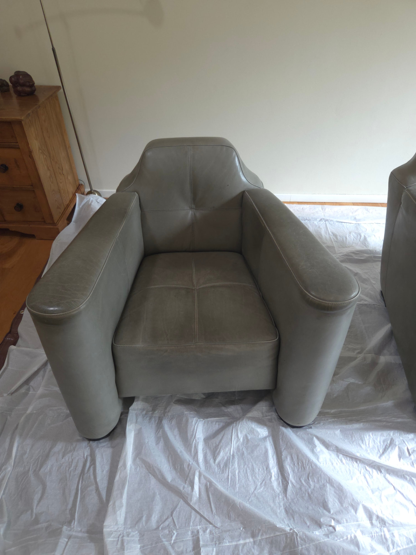 Voor behandeling: leren fauteuil met zichtbare slijtage en verkleuring